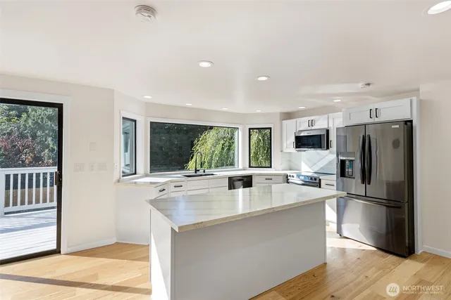 a kitchen with stainless steel appliances granite countertop a refrigerator and a sink