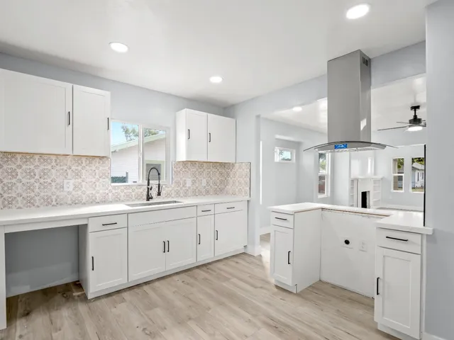 a kitchen with white cabinets and sink