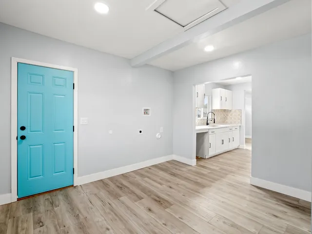 a view of a kitchen with a sink and wooden floor
