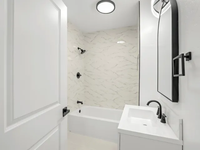 a bathroom with a sink a mirror and a bathtub