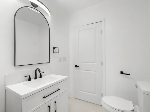 a bathroom with a sink a toilet and a mirror