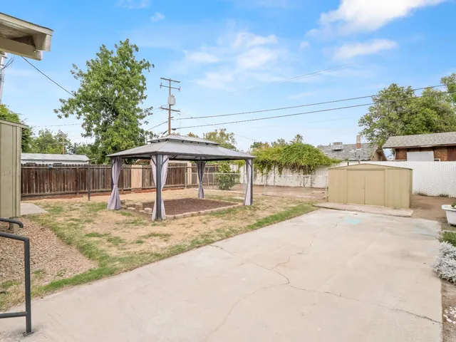a view of a house with a yard and large tree