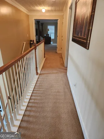 a view of a hallway with wooden floor and stairs