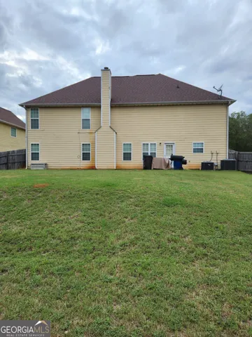a view of a house with a big yard and large trees