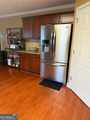 a kitchen with stainless steel appliances a refrigerator and wooden floor