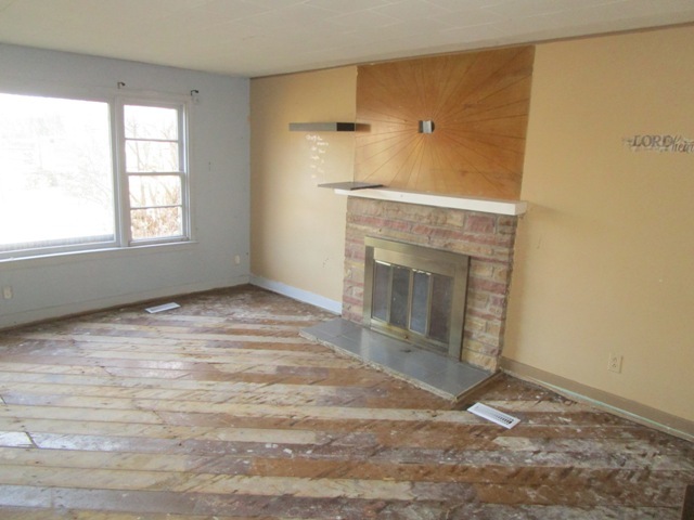 4405 Greenwood Road Woodstock, IL 60098 - Photo 6 of 10 an empty room with wooden floor and a fireplace