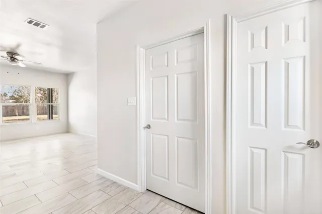 a view of a hallway with wooden shelves