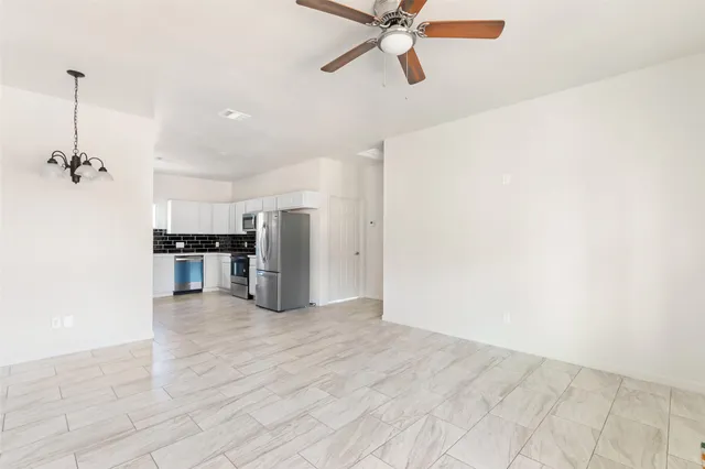 a view of a kitchen with a sink and refrigerator