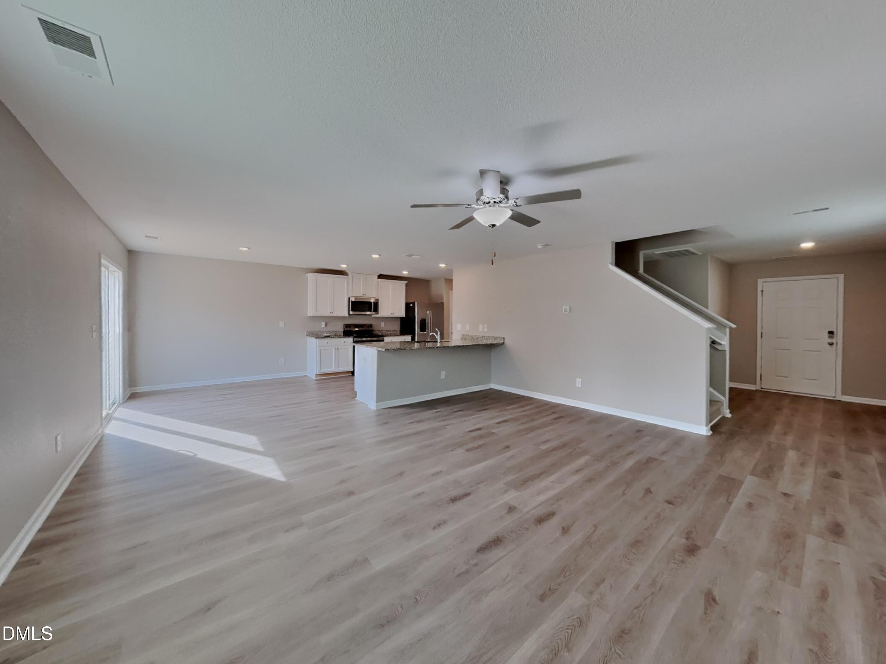 784 Frosty Way Zebulon, NC 27597 - Photo 2 of 15 a view of a livingroom with wooden floor and a ceiling fan