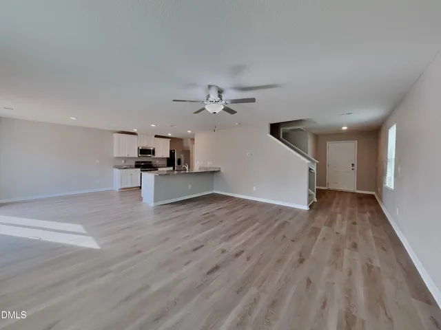 a view of a kitchen with wooden floor and a ceiling fan