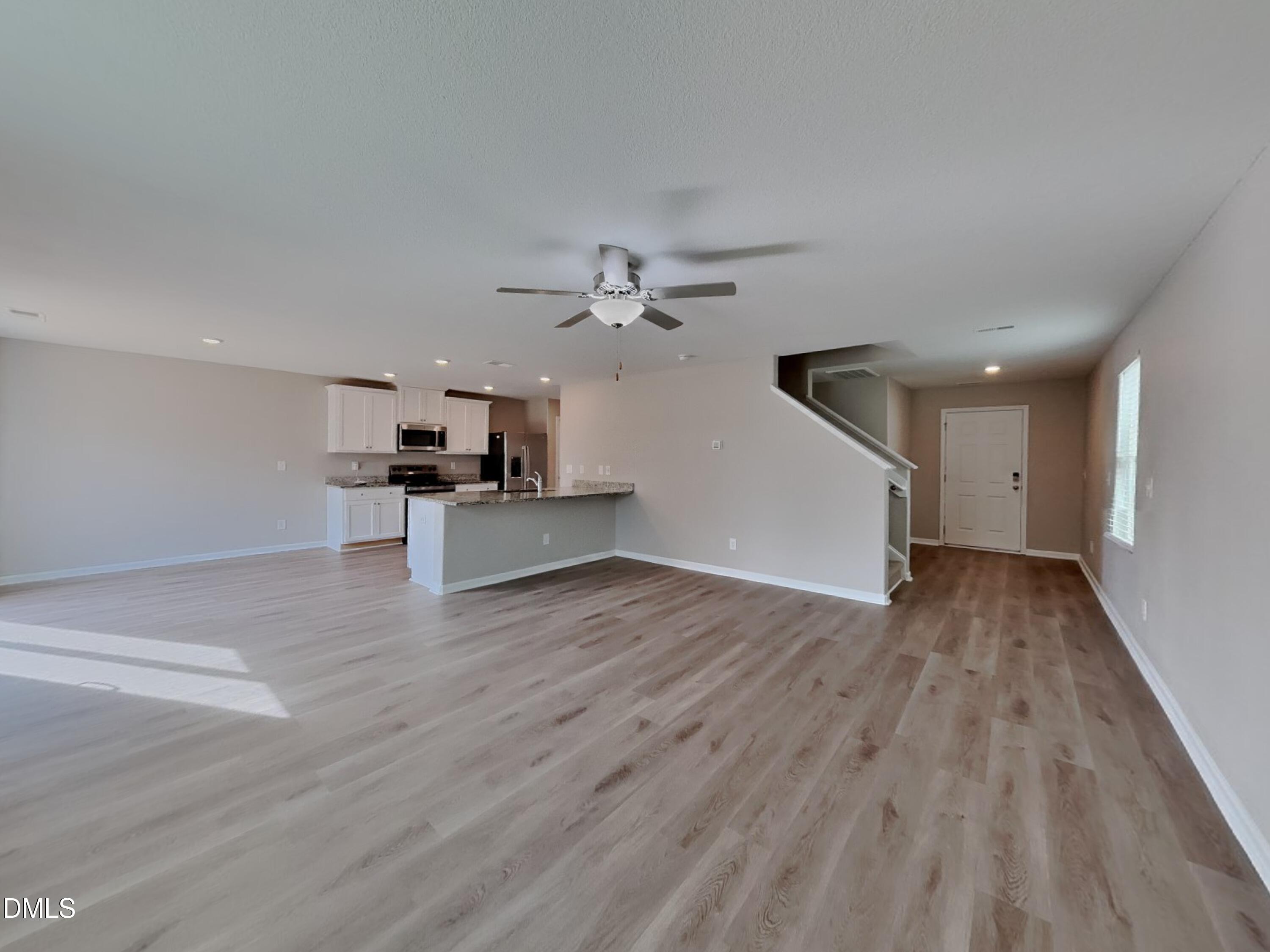784 Frosty Way Zebulon, NC 27597 - Photo 3 of 15 a view of a kitchen with wooden floor and a ceiling fan