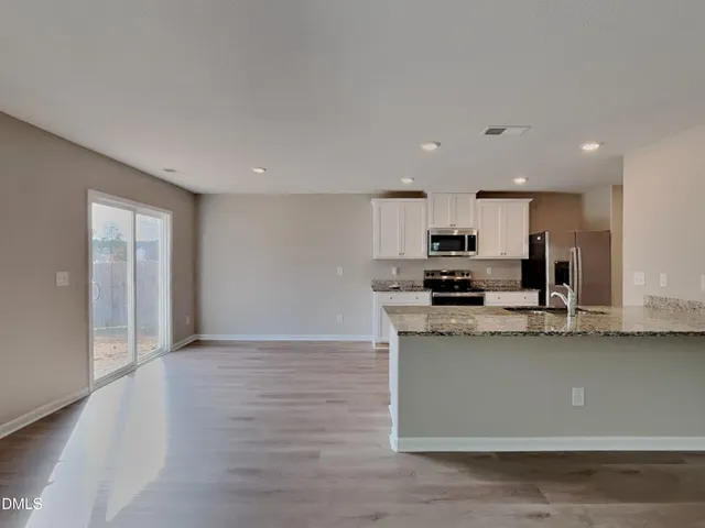 a kitchen with stainless steel appliances granite countertop a sink a stove a microwave and cabinets