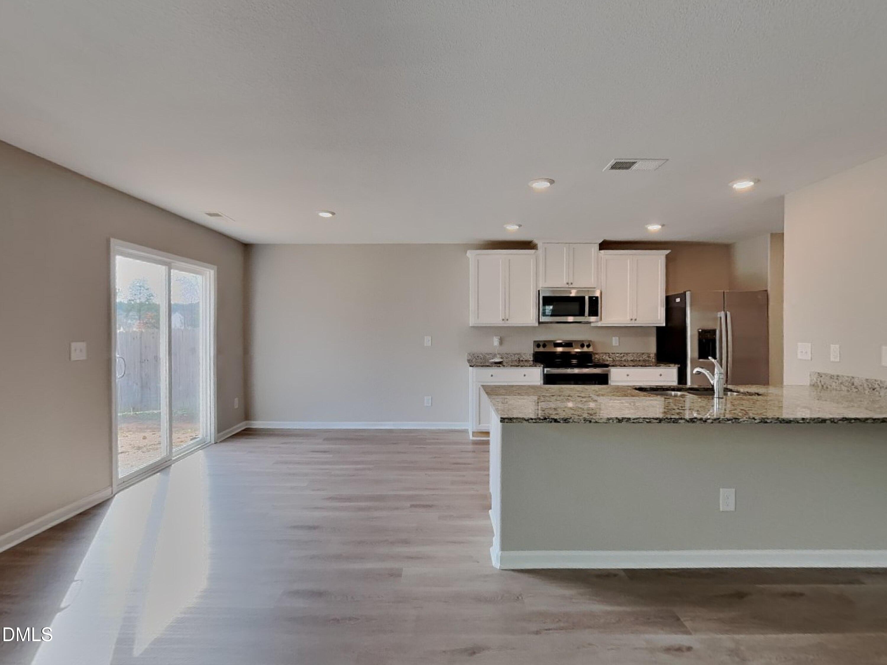 784 Frosty Way Zebulon, NC 27597 - Photo 4 of 15 a kitchen with stainless steel appliances granite countertop a sink a stove a microwave and cabinets