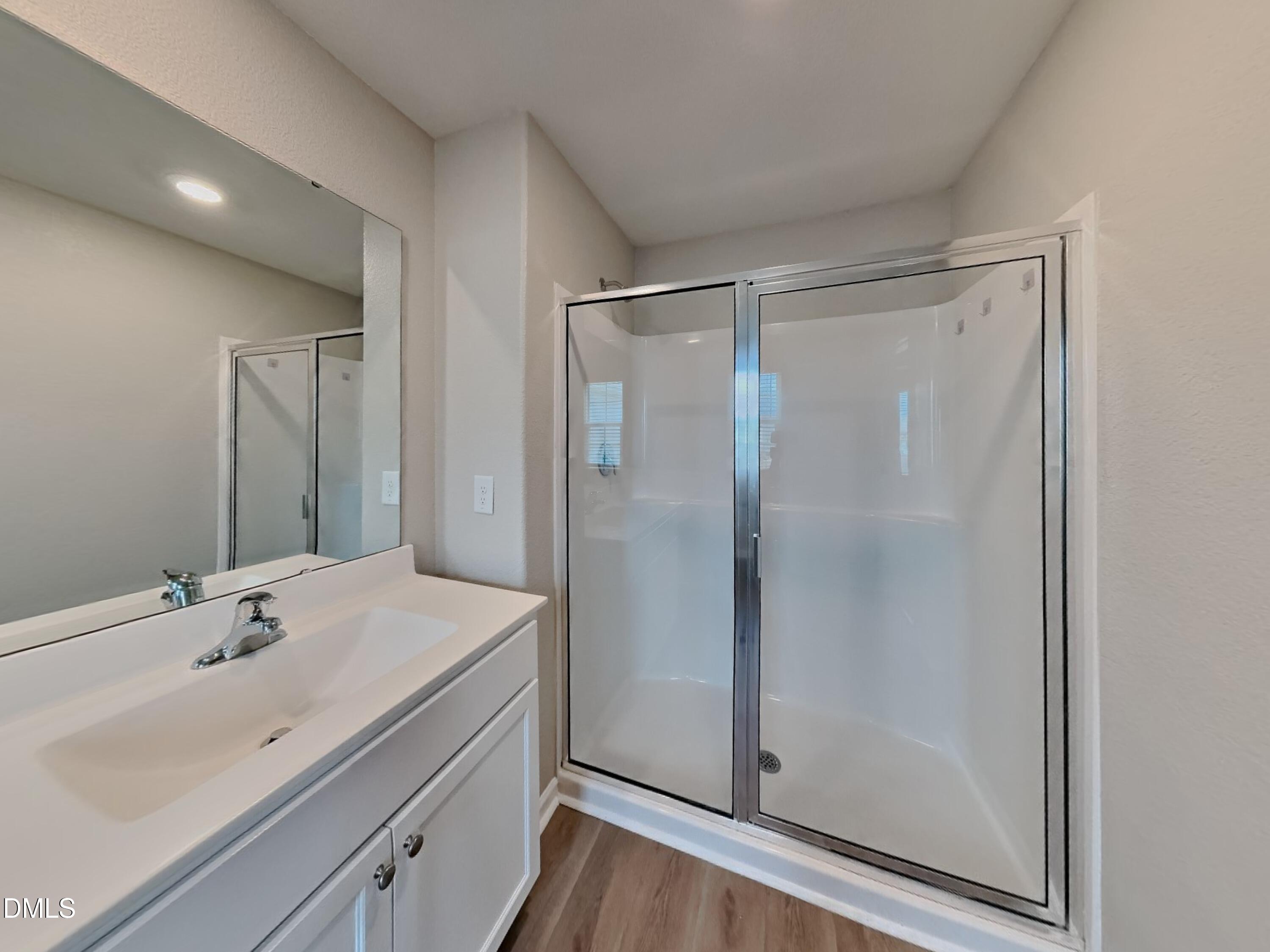 784 Frosty Way Zebulon, NC 27597 - Photo 8 of 15 a bathroom with a shower sink vanity and mirror