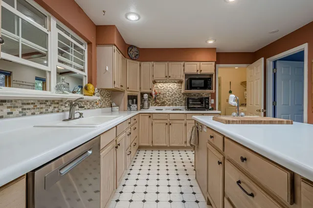 a kitchen with stainless steel appliances a sink a stove and cabinets