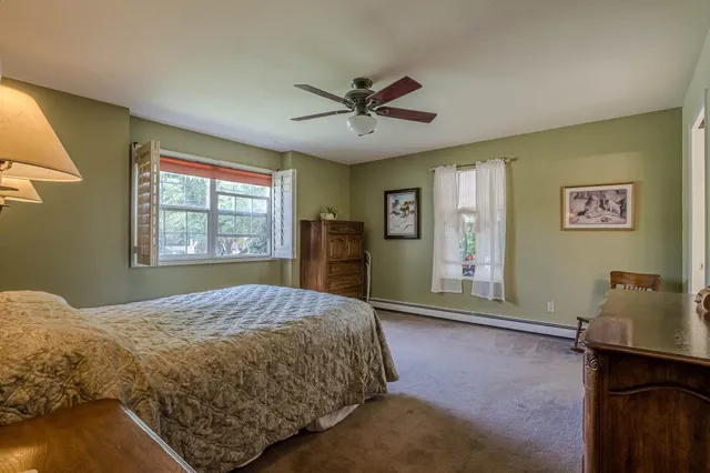 a bedroom with a bed and a dresser next to a window