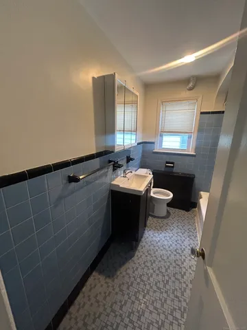 a spacious bathroom with a bathtub sink toilet and mirror