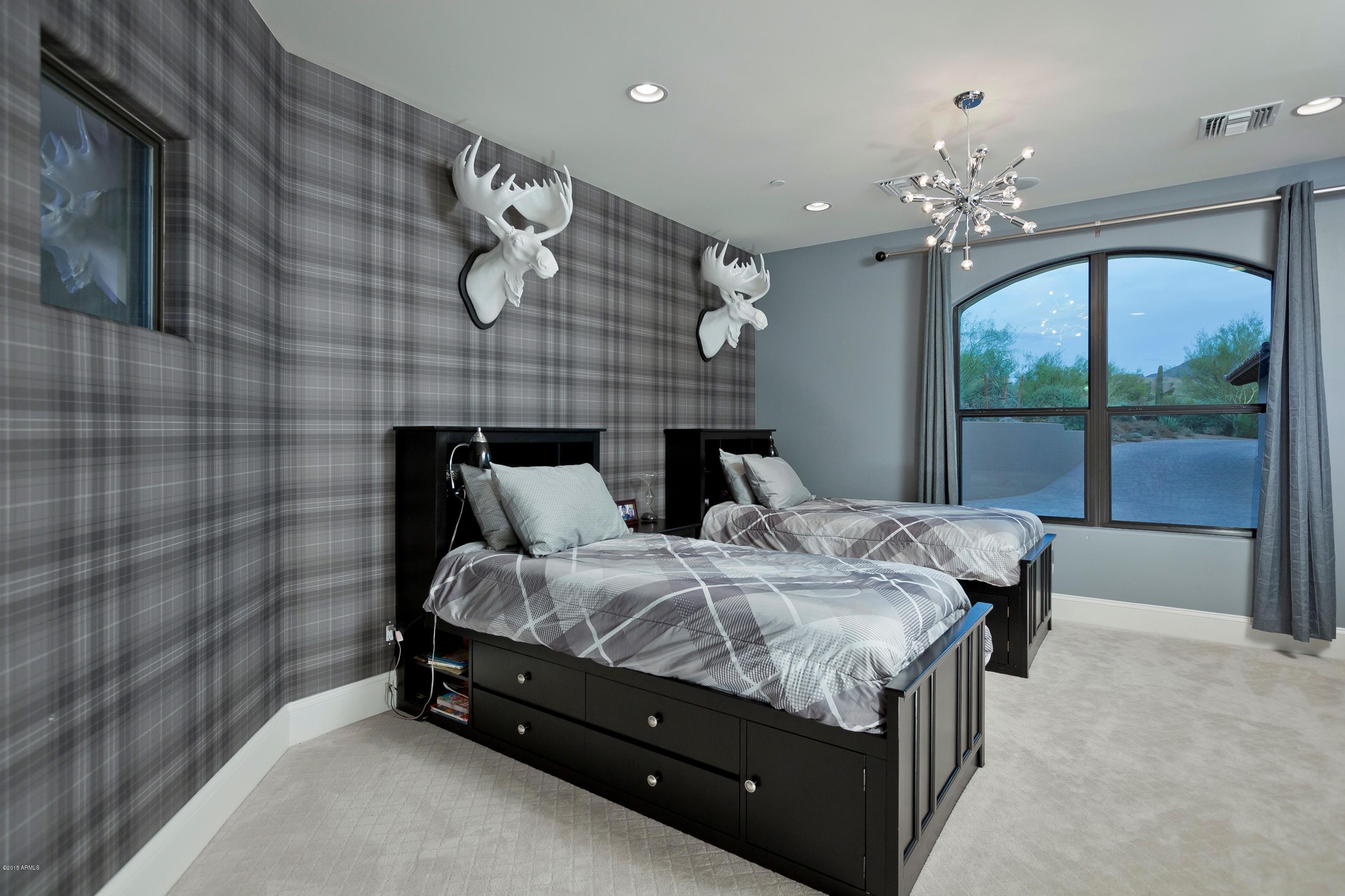 10040 East Happy Valley Road, Unit 14 Scottsdale, AZ 85255 - Photo 16 of 21 a bed sitting in a spacious bedroom next to a chandelier