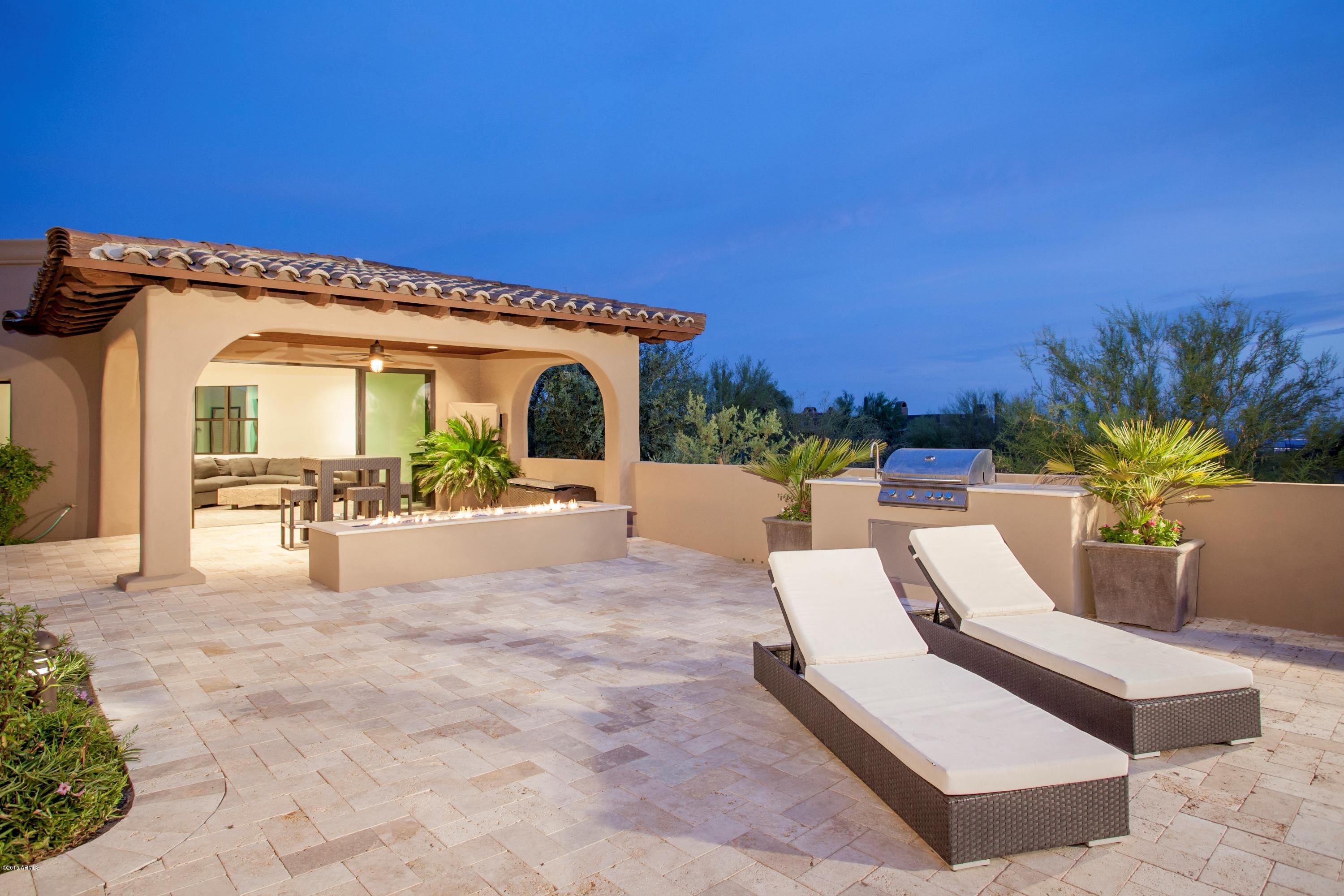 10040 East Happy Valley Road, Unit 14 Scottsdale, AZ 85255 - Photo 18 of 21 a view of a patio with a table and chairs under an umbrella