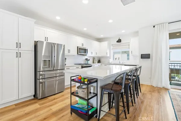 a kitchen with stainless steel appliances granite countertop a refrigerator and a stove top oven