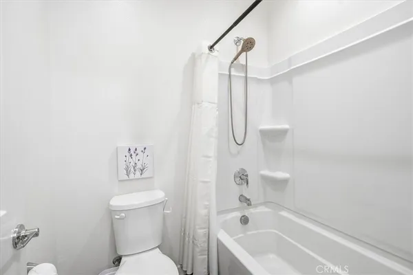 a white toilet sitting next to a bath tub