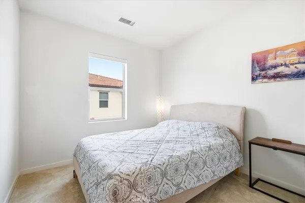 a bedroom with a bed and a painting on the wall