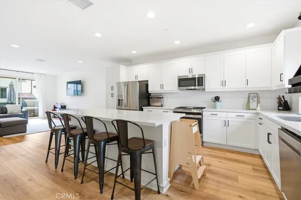 a kitchen with granite countertop white cabinets and stainless steel appliances