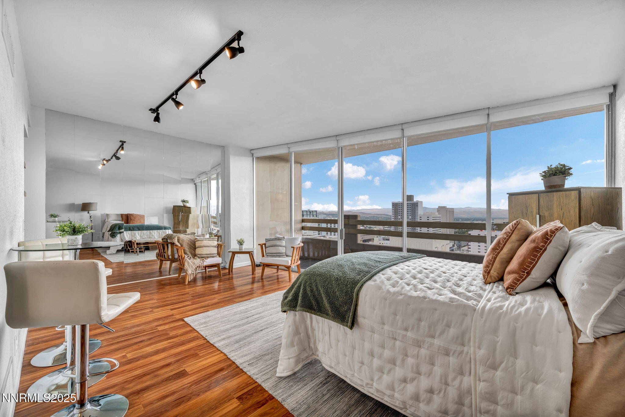 100 North Arlington Avenue, Unit 22C Reno, NV 89501 - Photo 7 of 34 a bedroom with a bed a table and chairs with wooden floor