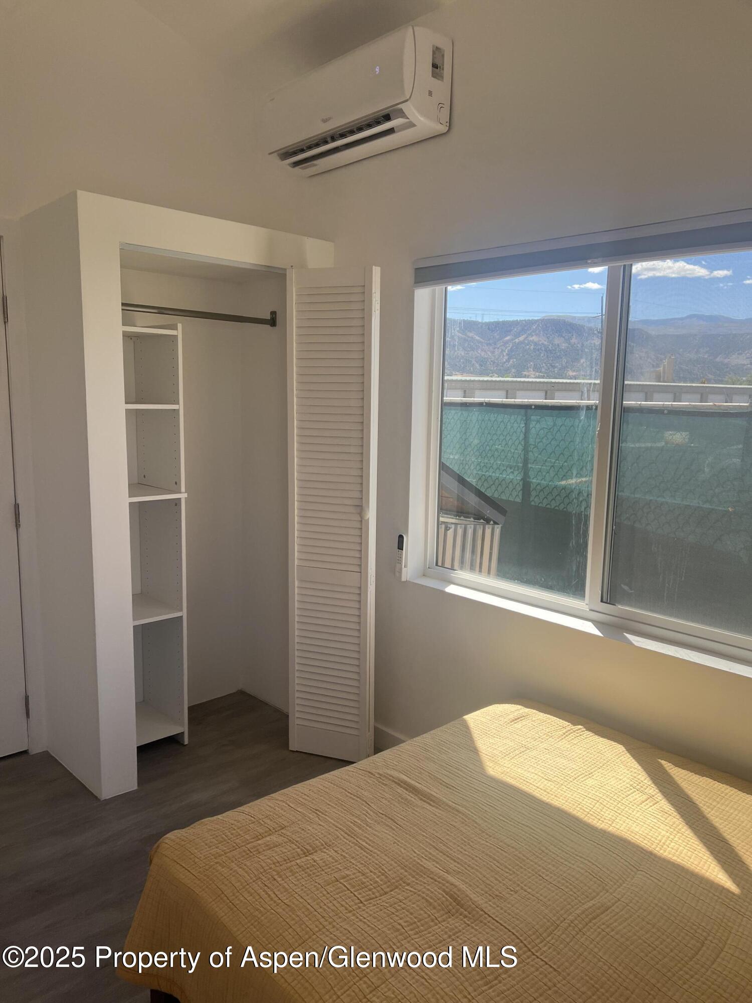 282 Cowboy Drive Rifle, CO 81650 - Photo 9 of 13 a view of a bedroom with wooden floor and windows