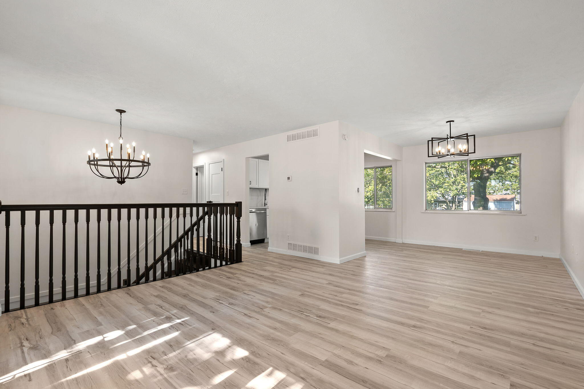 654 Cheyenne Drive Lowell, IN 46356 - Photo 3 of 11 an empty room with wooden floor chandelier and windows