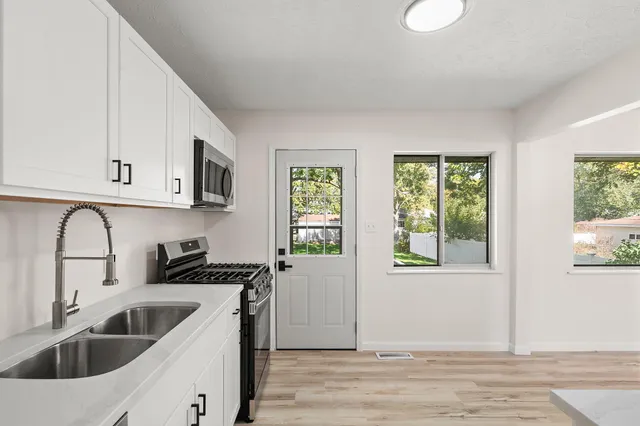 a kitchen with stainless steel appliances granite countertop a sink a stove a microwave and cabinets