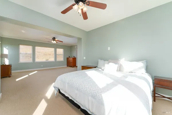 a bedroom with a bed and painting on the wall