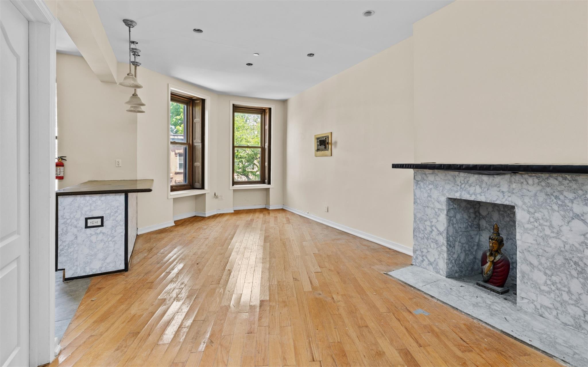 626 Madison Street Brooklyn, NY 11221 - Photo 20 of 42 Unfurnished living room featuring light wood-style flooring, a premium fireplace, and baseboards