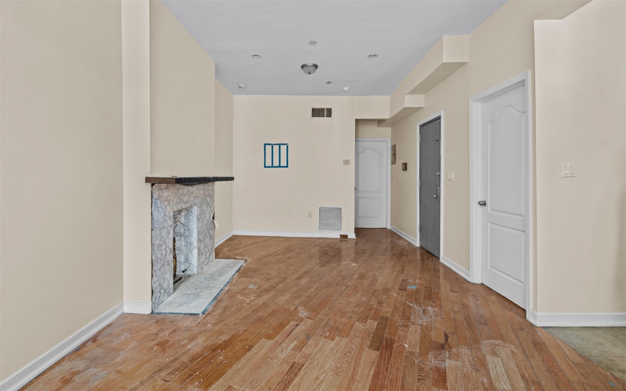 626 Madison Street Brooklyn, NY 11221 - Photo 25 of 42 Unfurnished living room with light wood finished floors, baseboards, and a stone fireplace