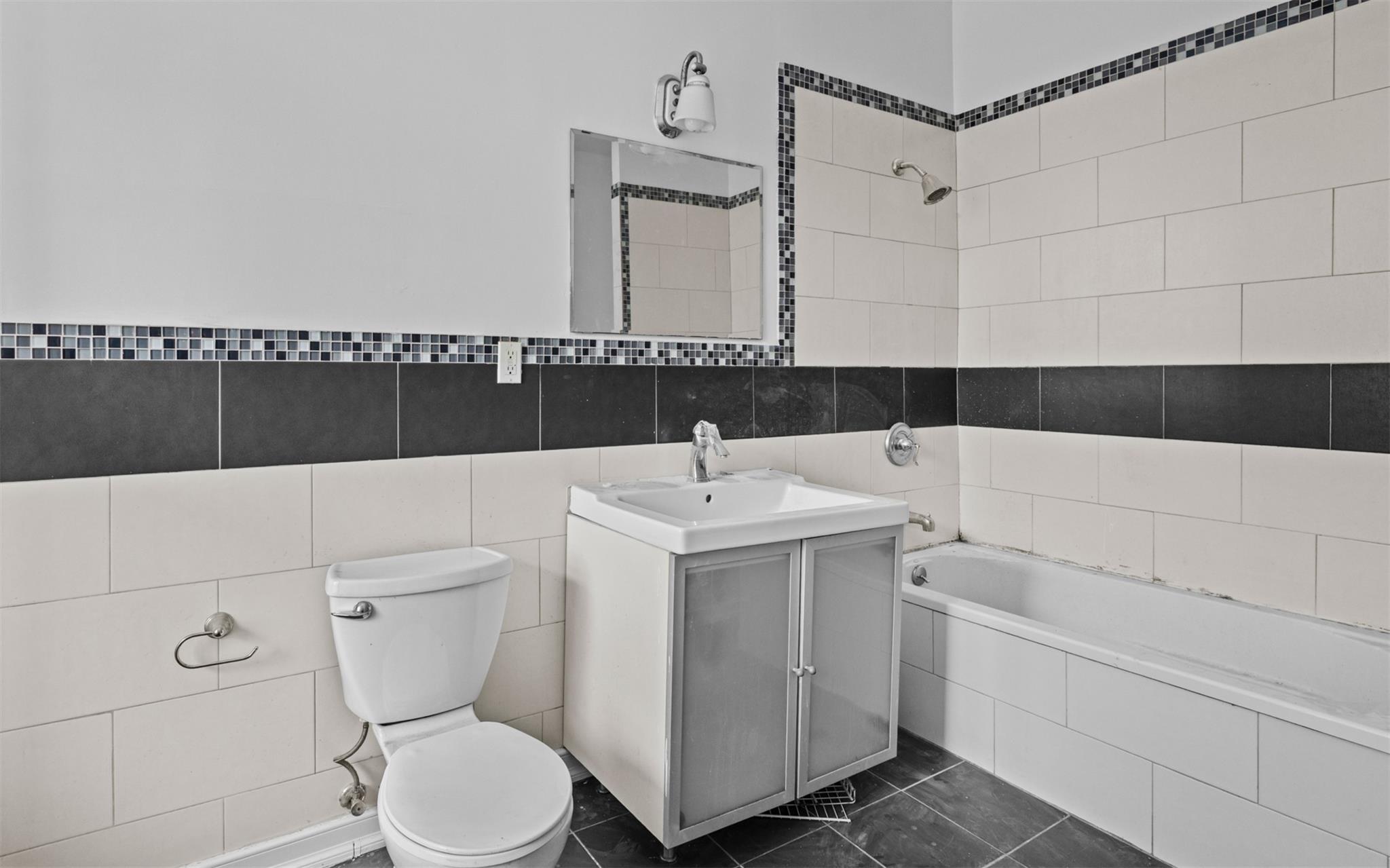 626 Madison Street Brooklyn, NY 11221 - Photo 28 of 42 Full bathroom featuring tile walls, vanity, toilet, and tiled shower / bath