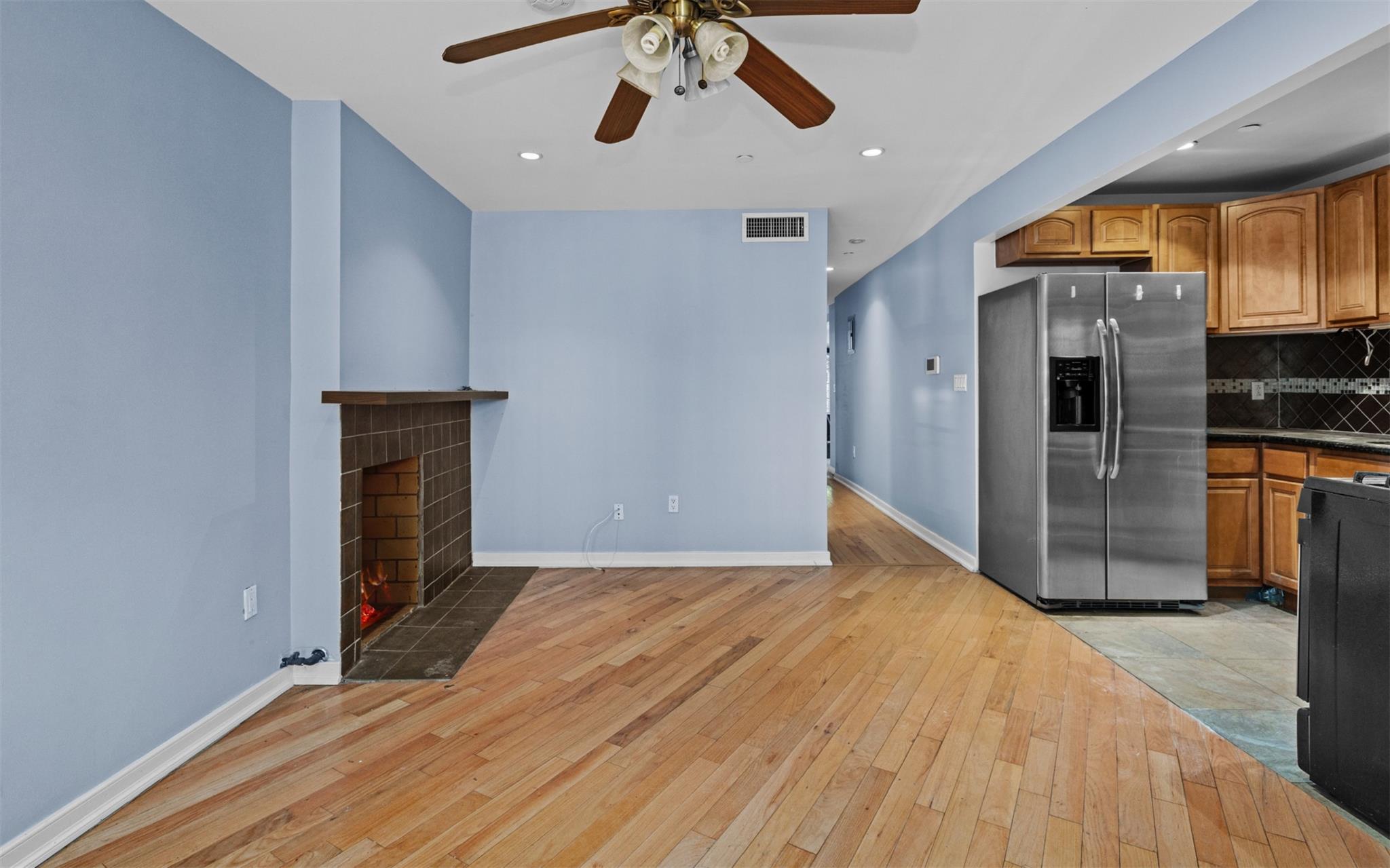 626 Madison Street Brooklyn, NY 11221 - Photo 3 of 42 Kitchen featuring stainless steel fridge with ice dispenser, light wood-style flooring, a ceiling fan, decorative backsplash, and baseboards