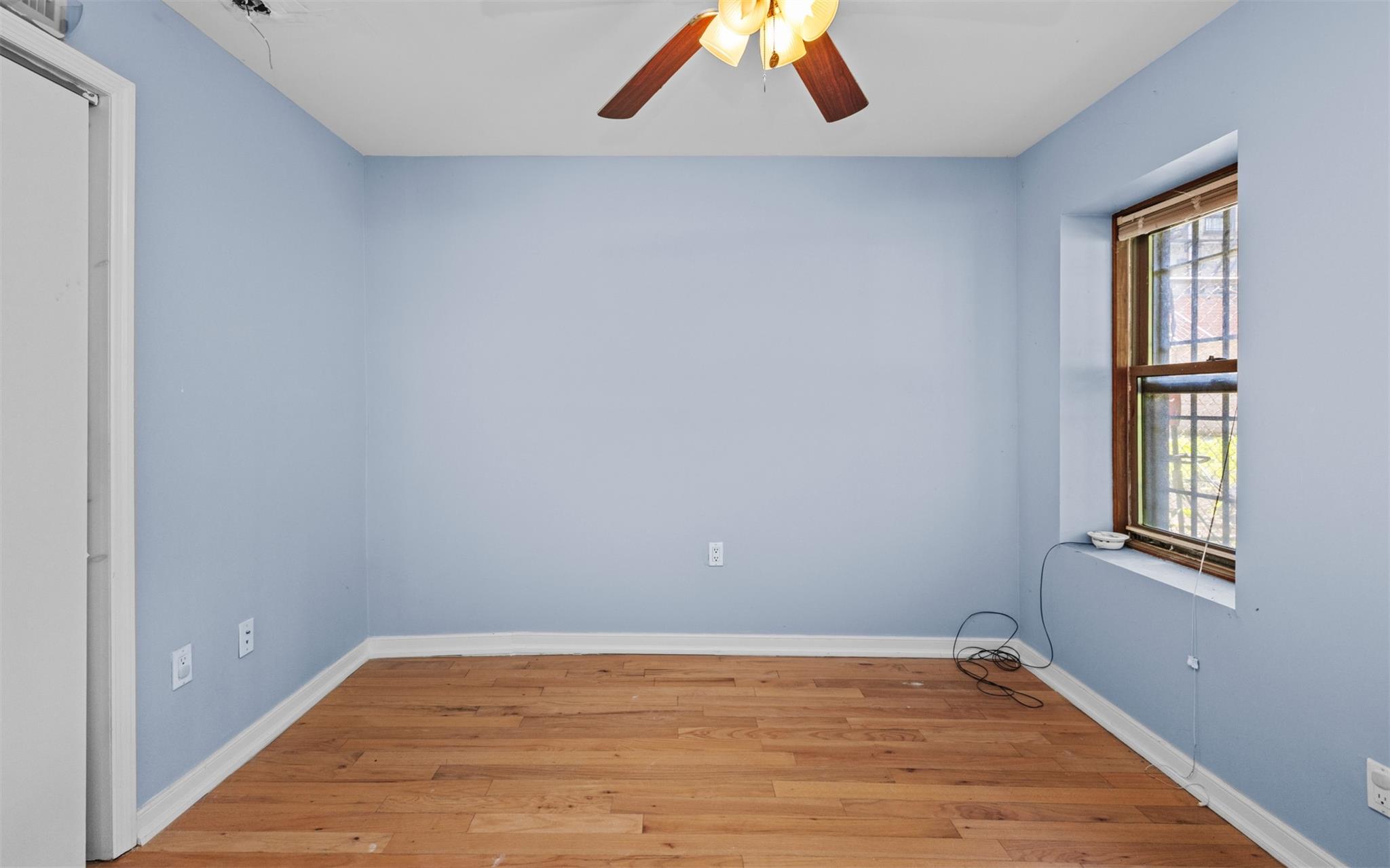 626 Madison Street Brooklyn, NY 11221 - Photo 9 of 42 Spare room with light wood-style floors, ceiling fan, and baseboards