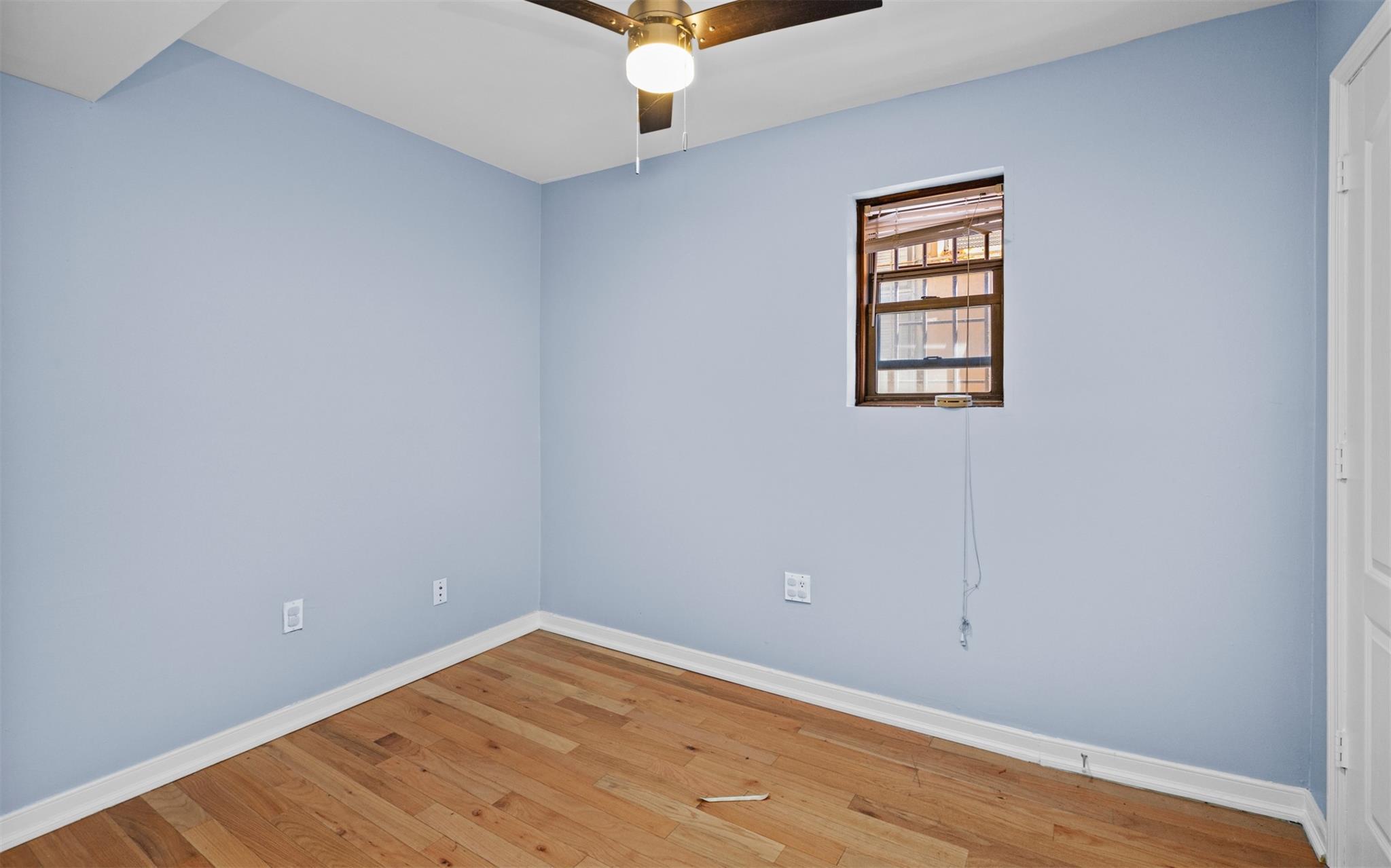 626 Madison Street Brooklyn, NY 11221 - Photo 10 of 42 Unfurnished room featuring baseboards, light wood-style flooring, and ceiling fan