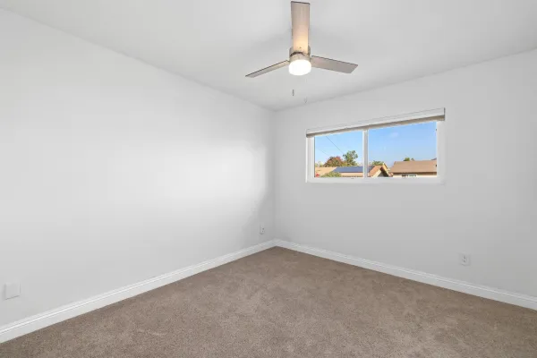 an empty room with a chandelier fan