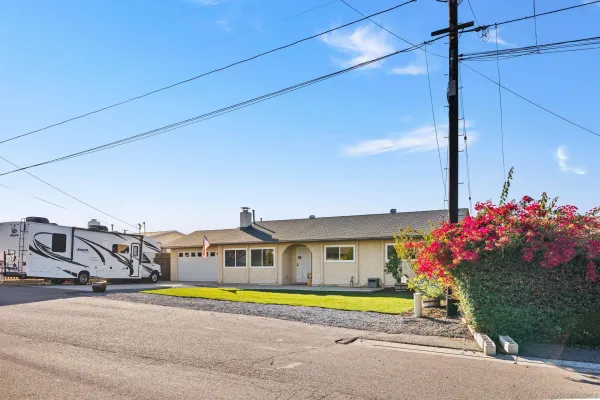 a front view of a house with a yard and a car