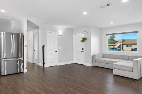 a living room with furniture and a refrigerator