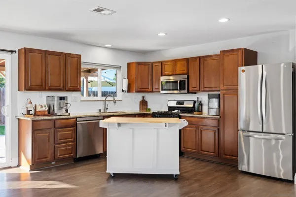 a kitchen with stainless steel appliances granite countertop a refrigerator stove microwave and sink