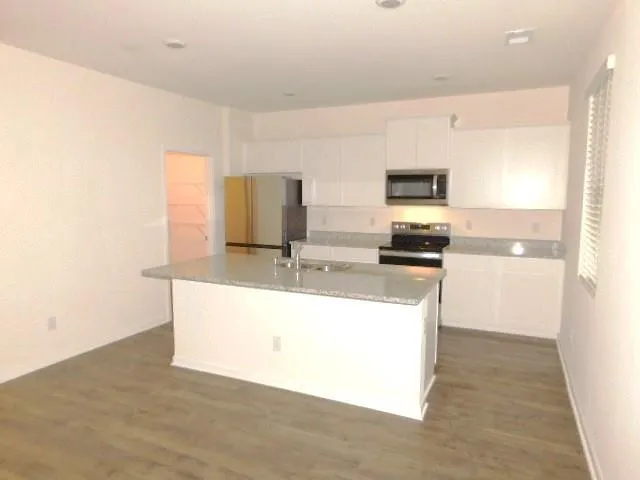 a kitchen with stainless steel appliances a refrigerator and a stove top oven
