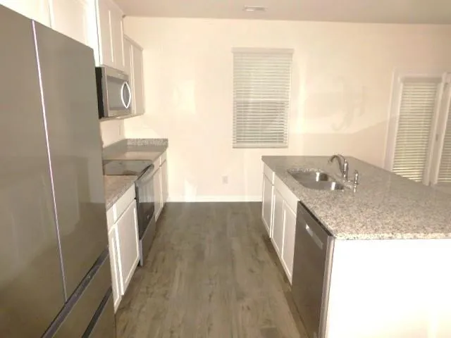 a bathroom with a granite countertop sink a washer and dryer