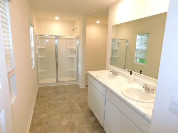 a bathroom with a granite countertop sink a mirror and a shower