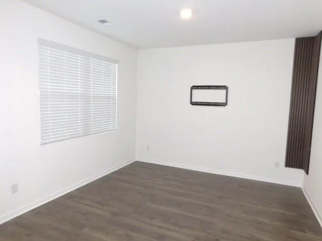 an empty room with wooden floor and a window