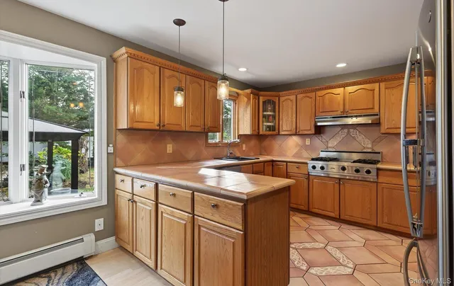 a kitchen with stainless steel appliances granite countertop a sink stove and refrigerator