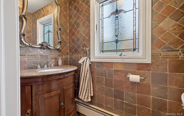 a bathroom with a granite countertop sink a mirror and shower
