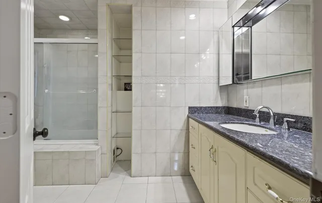 a bathroom with a granite countertop sink a toilet and shower