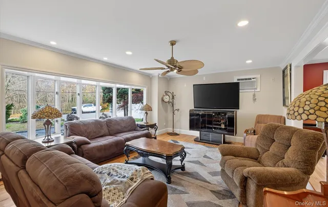 a living room with furniture a flat screen tv and a large window